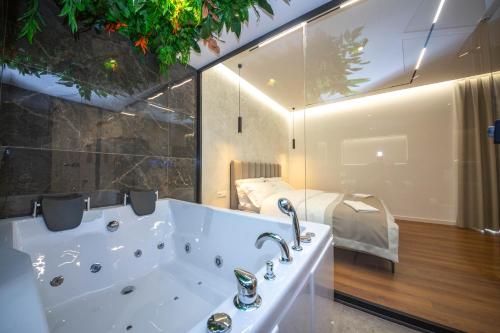 地拉那Hotel Riviera的带浴缸和床的大型浴室