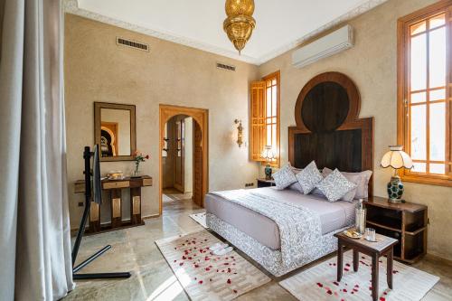 马拉喀什Palais Alcazar的一间卧室配有一张大床和镜子