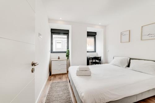 里斯本Lapa Stylish Apartments的白色卧室配有床和书桌