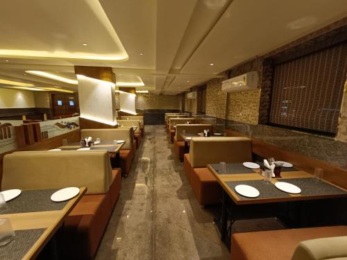 班加罗尔Hotel Classic Comfort的餐厅内带桌椅的用餐室