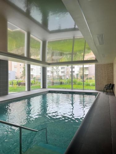 特雷利萨克Résidence Services Seniors DOMITYS - Les Galopins的一座大型游泳池,位于一座带窗户的建筑内