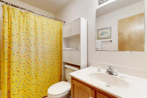 埃文The Beacon 95的浴室设有黄色的淋浴帘和水槽