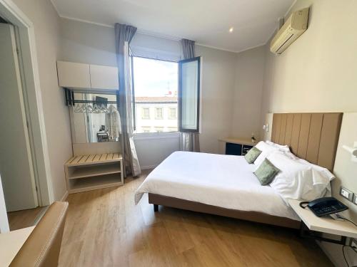 佛罗伦萨贾波内酒店的一间卧室配有一张床、一张书桌和一个窗户。