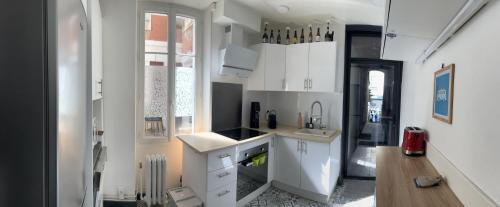 比亚里茨Chalet basque 6 couchages centre ville Biarritz的厨房配有白色橱柜和水槽