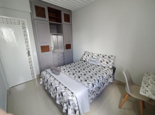 库亚巴Quarto em apartamento em Cuiabá的一间白色的小卧室,配有一张床和一把椅子