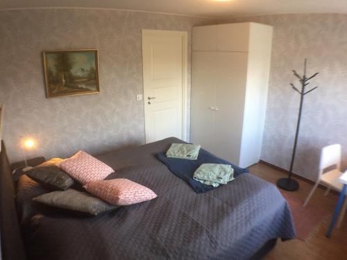 马尔默Dubbelrum med extrasäng på markplan i lugnt villaområde的一间卧室配有带枕头的床