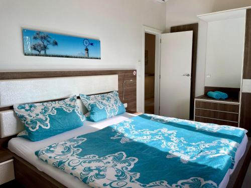 柳奇马约尔Villa Sun Club home的一张带蓝色和白色床单及枕头的床