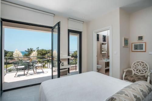 佩基罗德Oneiro Villa - Voted the best Villa in Rhodes, Greece!的一间卧室配有一张床,阳台配有桌子