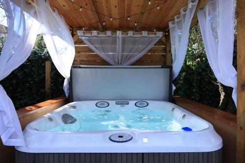 伯恩茅斯Le Chic Retreat - Luxury Hot Tub Getaway的浴缸位于房子后面