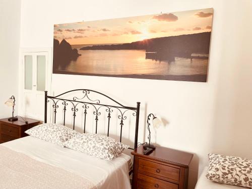 普蒂尼亚诺Arco Michele的卧室配有一张床,墙上挂有绘画作品