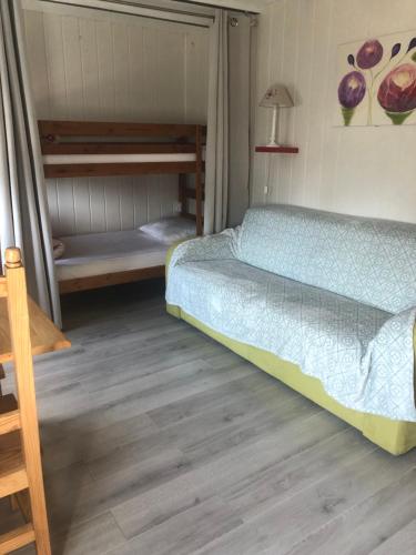 La ChâtelaineLe Petit Chalet的一间卧室配有一张床和两张双层床。