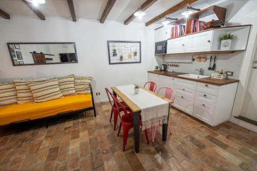 特雷维尼亚诺罗马诺Vicolo39 La casa a due passi dal Lago的一间带桌子和床的卧室以及一间厨房