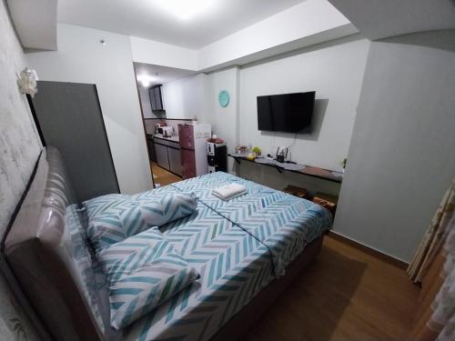 巴淡岛中心Sri Studio 07@Pollux Habibie Meisterstadt的一间卧室配有一张带蓝色和白色棉被的床