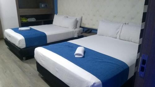 波哥大Plaza Miranda的一间酒店客房,配有两张床和枕头
