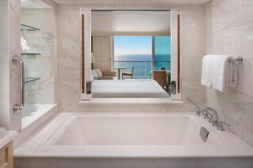 拉古纳海滩海浪和沙滩度假村 的带浴缸的浴室,享有海景。