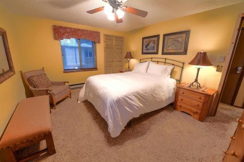 西黄石Trapper Condo Unit 3的卧室配有床、椅子和窗户。