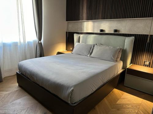 米兰V28的一间卧室配有一张带白色床单的大床