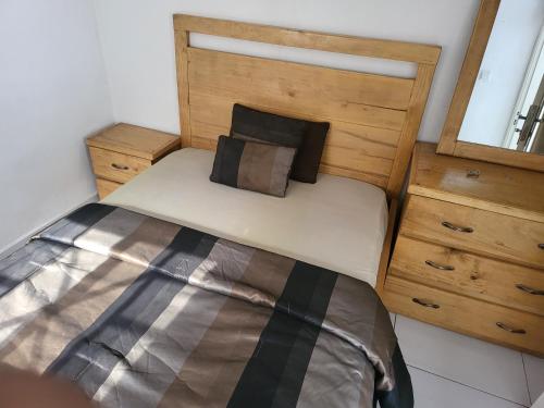 弗里敦Cozy 2 Bedroom Bungalow.的一间卧室配有一张带木制床头板的床