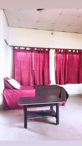 奇克马格尔Empire lodge的配有红色窗帘和桌子的床的房间