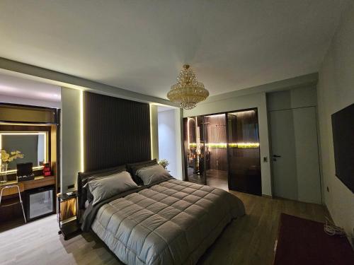 地拉那Blloku Suites, City Centre,Tirana的一间卧室配有一张床、一张书桌和一个吊灯。