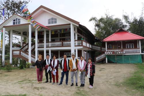 帕西加特Tsering's Homestay Oyan的一群站在房子前面的人