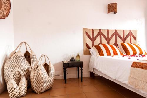 莱瓦镇Pancha Mama Hotel Boutique的一间卧室,配有一张带两个袋子的床