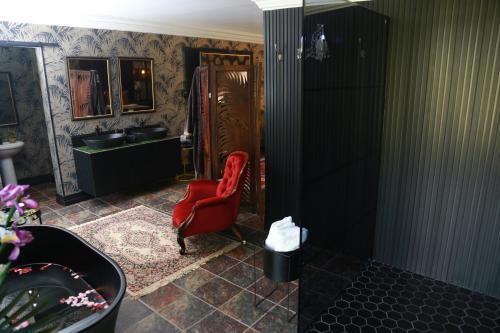 韦尔科姆Villa Grande Luxury accommodation的一间带红色椅子和水槽的浴室
