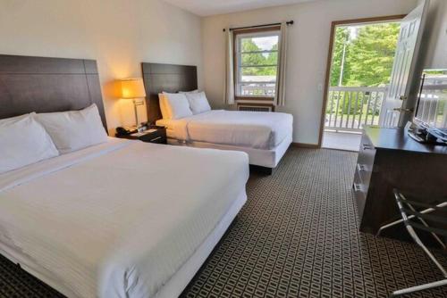 拉丁顿Nader's Motel & Suites的酒店客房设有两张床和一个阳台。
