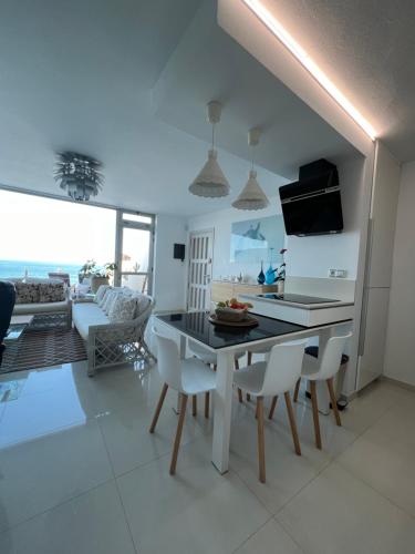 Playa del HombrePlaya del Hombre Deluxe Luxury Apartments的厨房以及带桌椅的起居室。