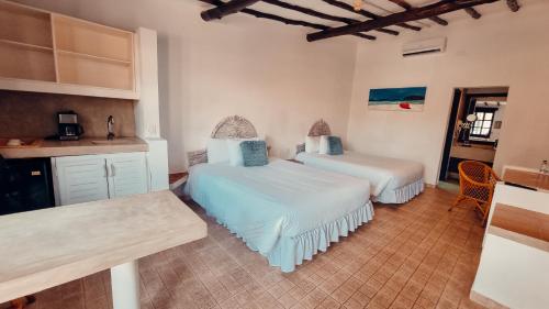 波拉马尔Hotel Margarita Village的一间带两张床的卧室和一间带柜台的厨房
