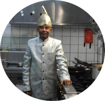 锡塔德SIMLA INDIAAS RESTAURANT VOOR KAMER的站在厨房里戴着厨师帽的人