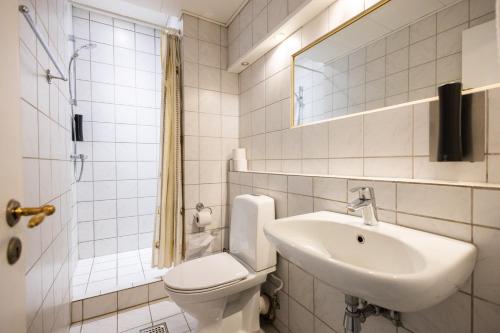 欧登塞Milling Hotel Windsor的白色的浴室设有卫生间和水槽。