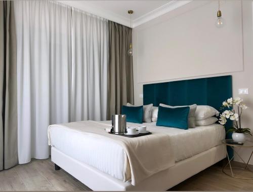 罗马NLM Boutique Suites的卧室配有一张蓝色色调的大型白色床。