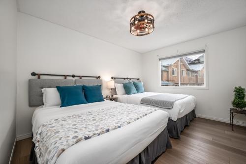 坎莫尔Luxurious Retreat/Hot Tub/Mountain View/4 Beds的白色客房的两张床,设有窗户