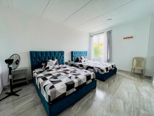 TauramenaHotel Campestre Morichal的一间卧室设有两张床和窗户。
