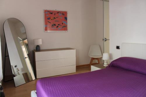 卡斯特拉玛雷帝斯达比亚Atlantide holiday apartments的一间卧室配有紫色的床、梳妆台和镜子