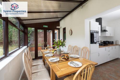 莱斯特Tetuan House - Syster Properties - Work -Family - Groups Leicester LE3的一间带木桌和椅子的用餐室