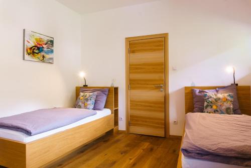 奥拉Julias Guesthouse的一间卧室设有两张床和一扇门