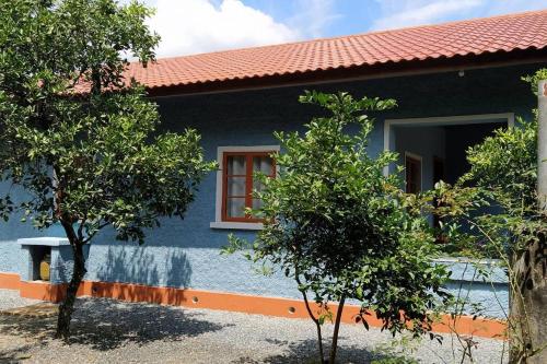 波梅罗迪Casa Centenária no centro de Pomerode的前面有树木的蓝色房子
