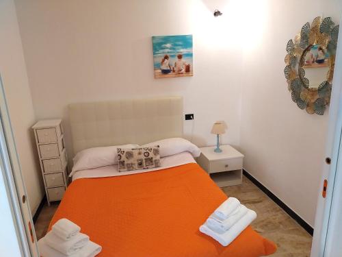 蒙特罗索阿尔马雷Fulvia's cozy apartment with terrace的小卧室配有带橙色毯子的床
