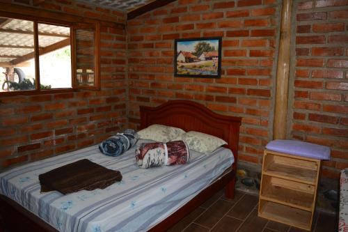 伊瓦拉Casa de campo independiente sector Chachimbiro –Urcuqui的卧室配有砖墙内的床铺