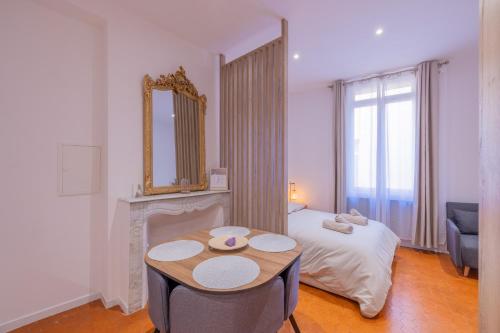 普罗旺斯艾克斯Appartement de Charme的客房设有床、桌子和镜子