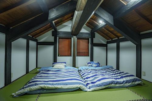 四街道市Ichishuku Ikkei Issei-Chiba Prefecture Yotsukaido - Vacation STAY 16242的配有木天花板的客房设有两张床。
