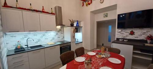 布达佩斯Palace Apartment的厨房配有一张桌子,上面有红色的桌布