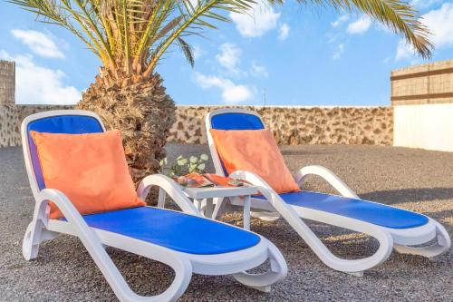 拉哈雷斯Casa Filale Sun and Relax的两把沙滩椅,坐在棕榈树旁边