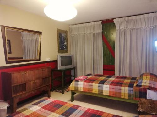奥塔瓦洛飞驴住宿加早餐旅馆的一间卧室配有两张床和电视。
