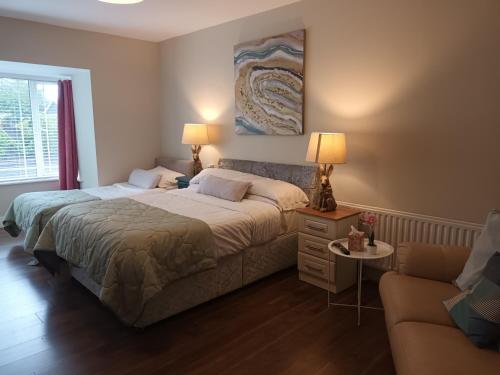 布拉尼Mulberry Lodge的一间带两张床和一张沙发的卧室