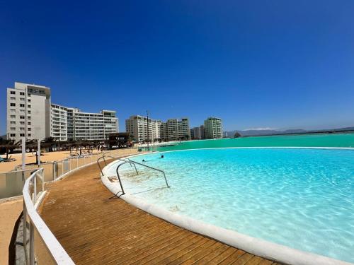 拉塞雷纳Dpto en Resort Laguna del Mar frente al mar 2D2B的海滩上的大型游泳池,拥有建筑