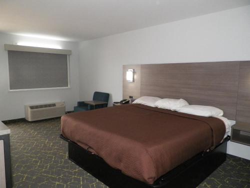 罗兰Walnut Inn的酒店客房设有一张大床和一个黑板