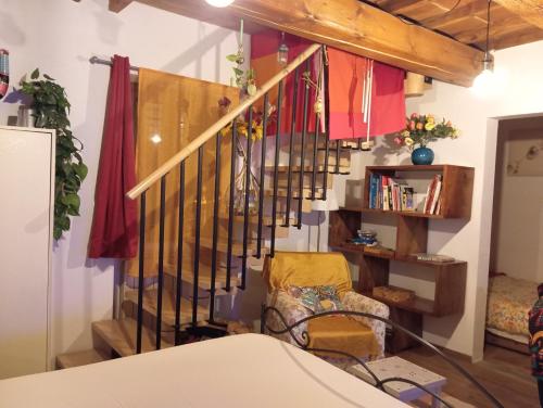巴尼奥阿里波利I Rosai appartamento sulle colline fiorentine的一间带椅子和书架的楼梯间